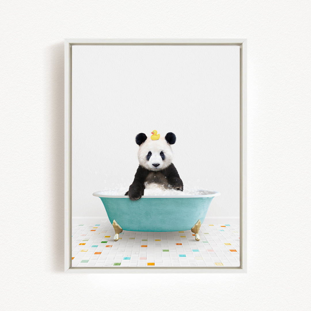 A panda bear sitting in a blue bathtub filled with bubbles, with a yellow rubber duck floating on the water.