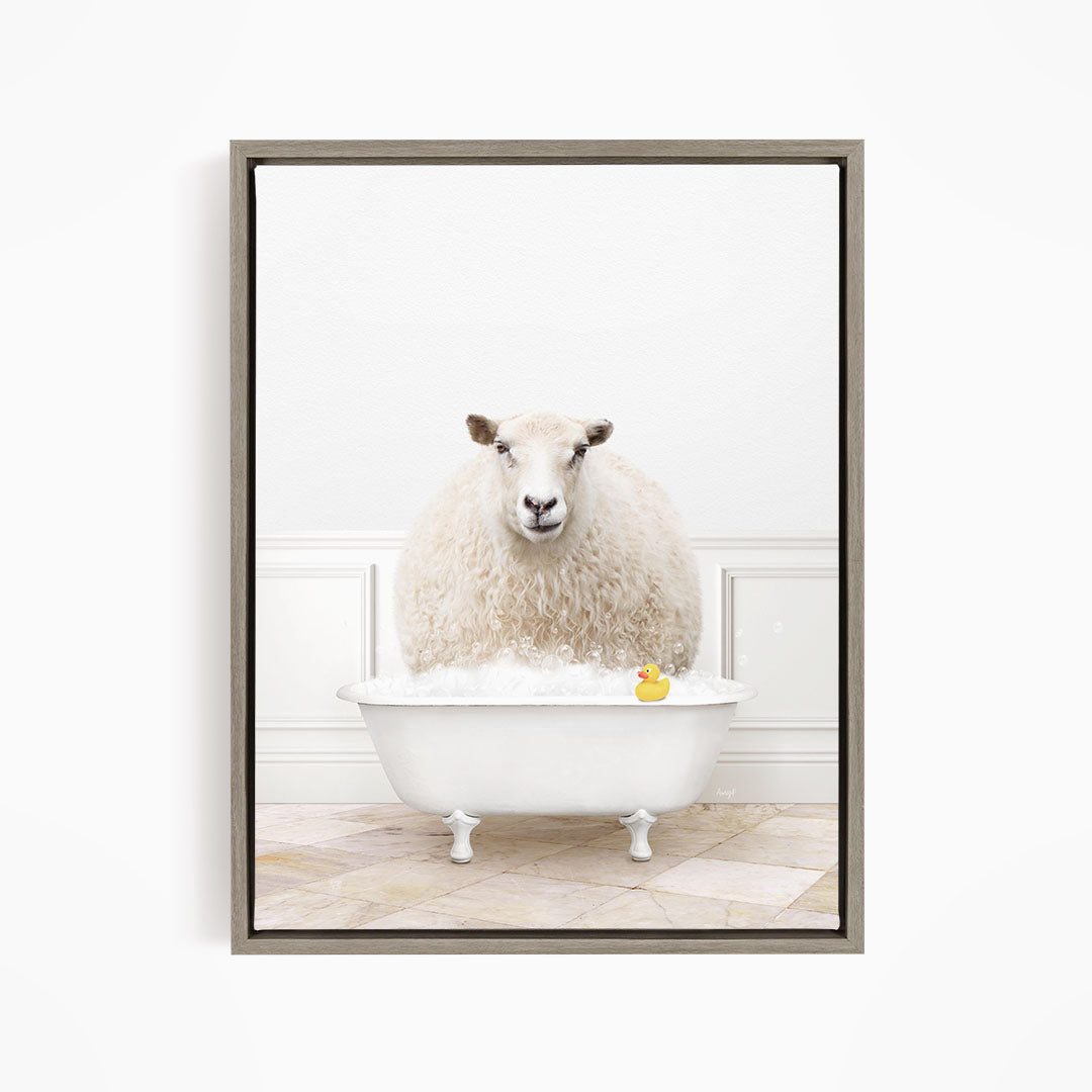 A fluffy white sheep sits in a white bathtub filled with bubbles, with a yellow rubber duck floating in the water.