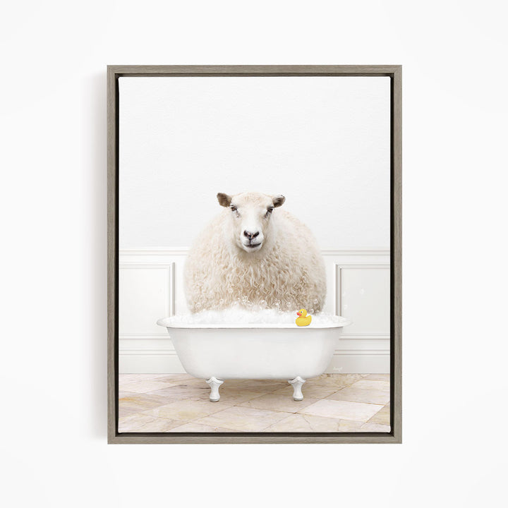 A fluffy white sheep sits in a white bathtub filled with bubbles, with a yellow rubber duck floating in the water.