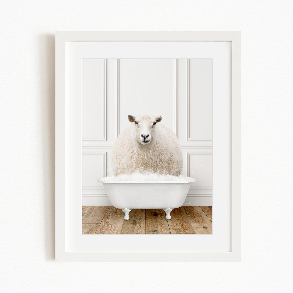 A fluffy white sheep sits in a white bathtub, surrounded by a white wall and wooden floor.