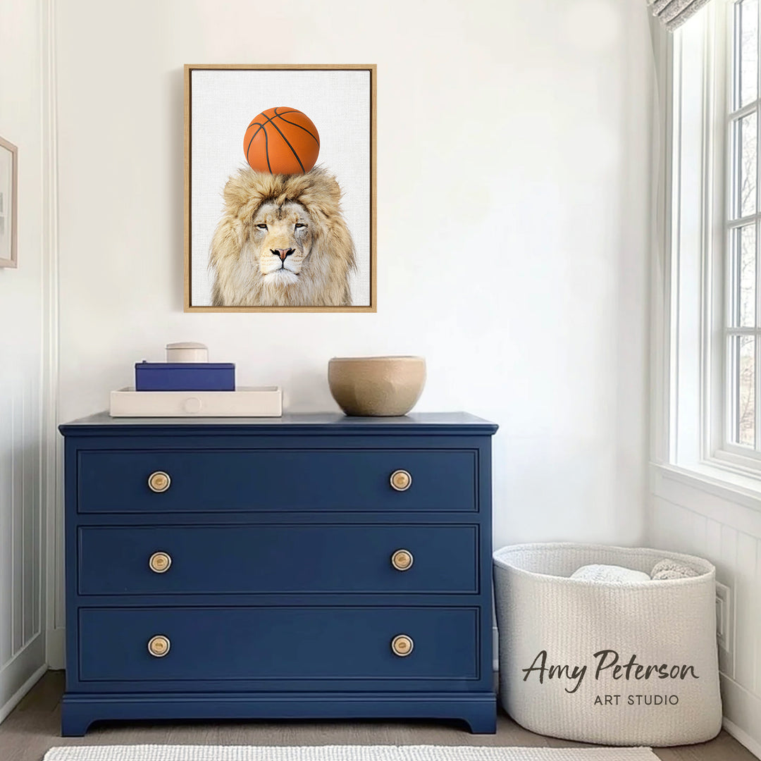 a blue dresser with a framed picture of a lion wearing a basketball on its head, and a white basket next to it.