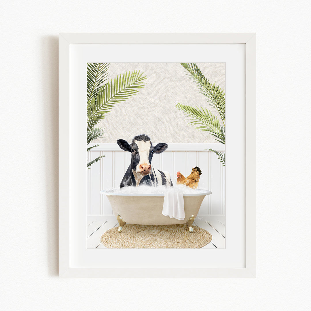 A black and white cow is sitting in a bathtub filled with water, surrounded by palm leaves, with a chicken nearby.
