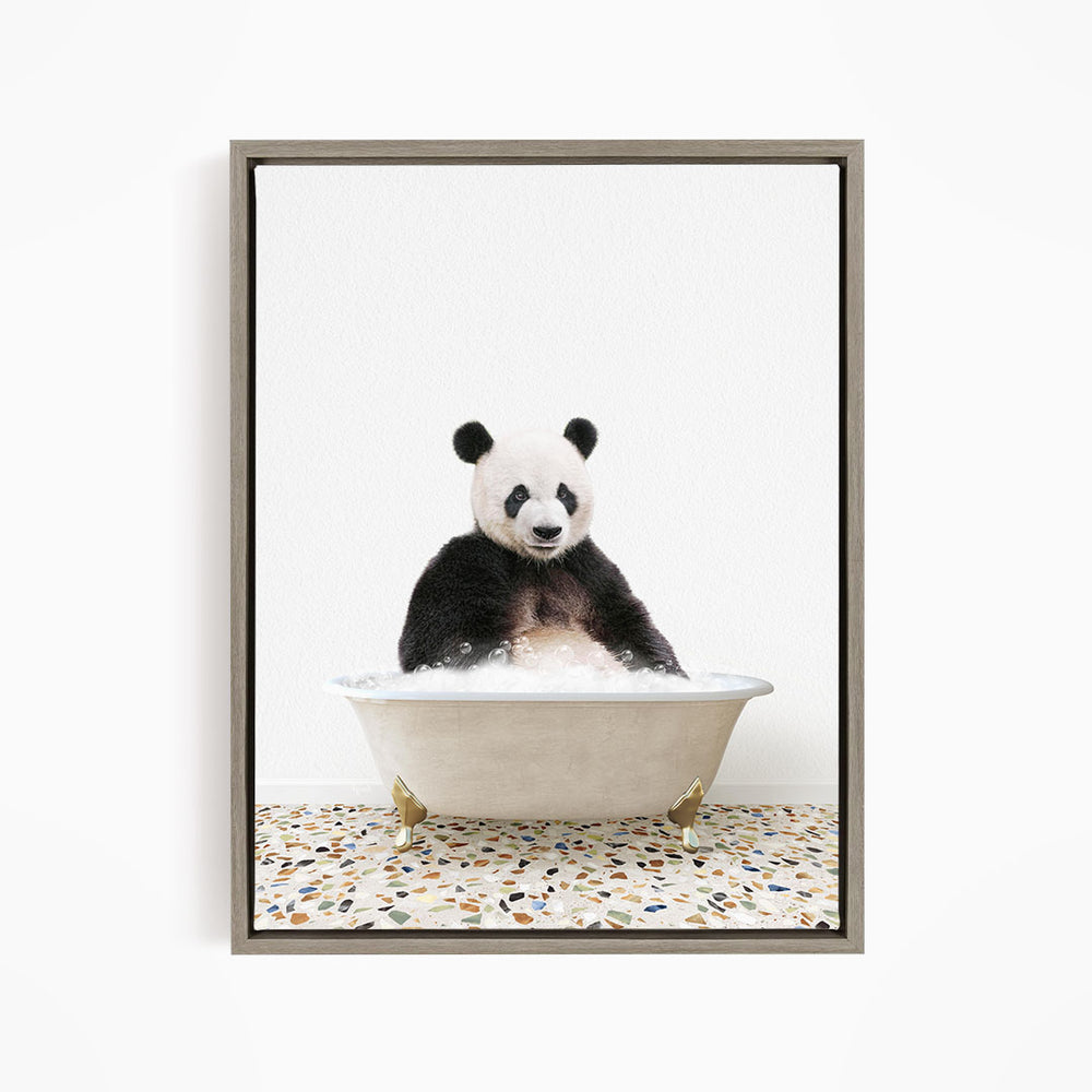 A panda bear sitting in a white bathtub filled with bubbles, looking directly at the camera.