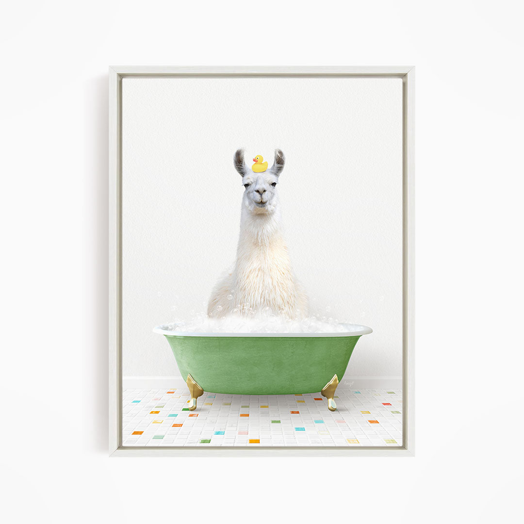 A white llama sitting in a green bathtub filled with bubbles, with a yellow rubber duck floating on its head.