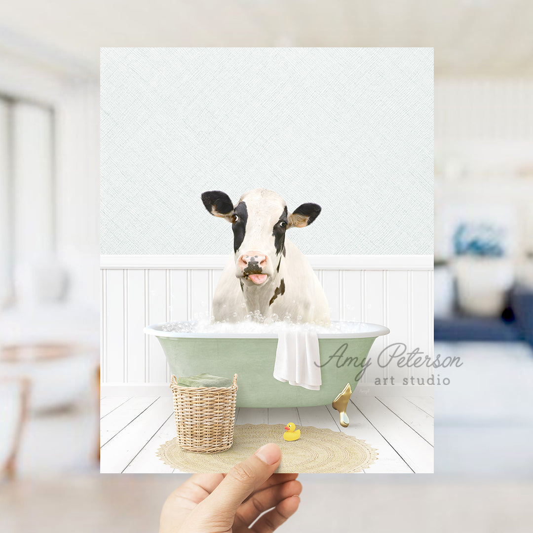 a person holding up a picture of a cow in a bathtub