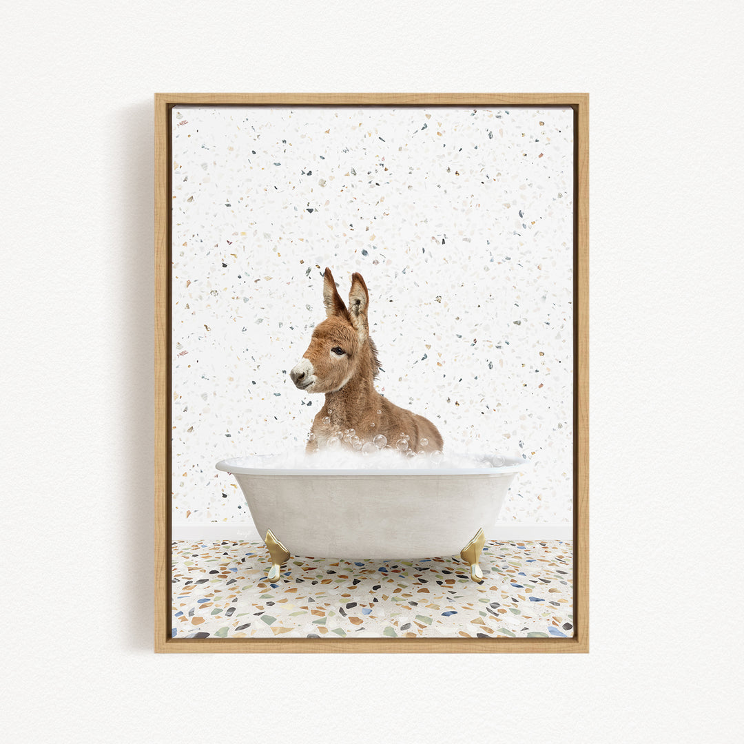 A donkey is sitting in a white bathtub filled with water, surrounded by a speckled background.