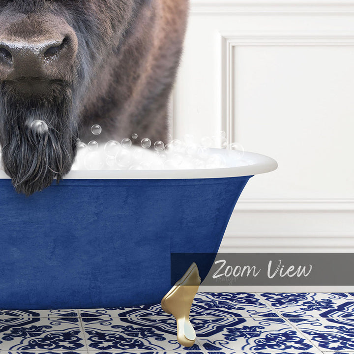 A close-up of a dog's face peeking over the edge of a blue bathtub filled with bubbles, with a gold faucet and a patterned tile floor visible in the background.