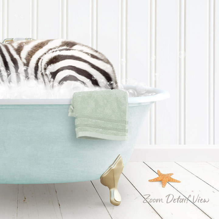 A zebra lying in a light blue bathtub, surrounded by bubbles, with a green towel and a starfish nearby.