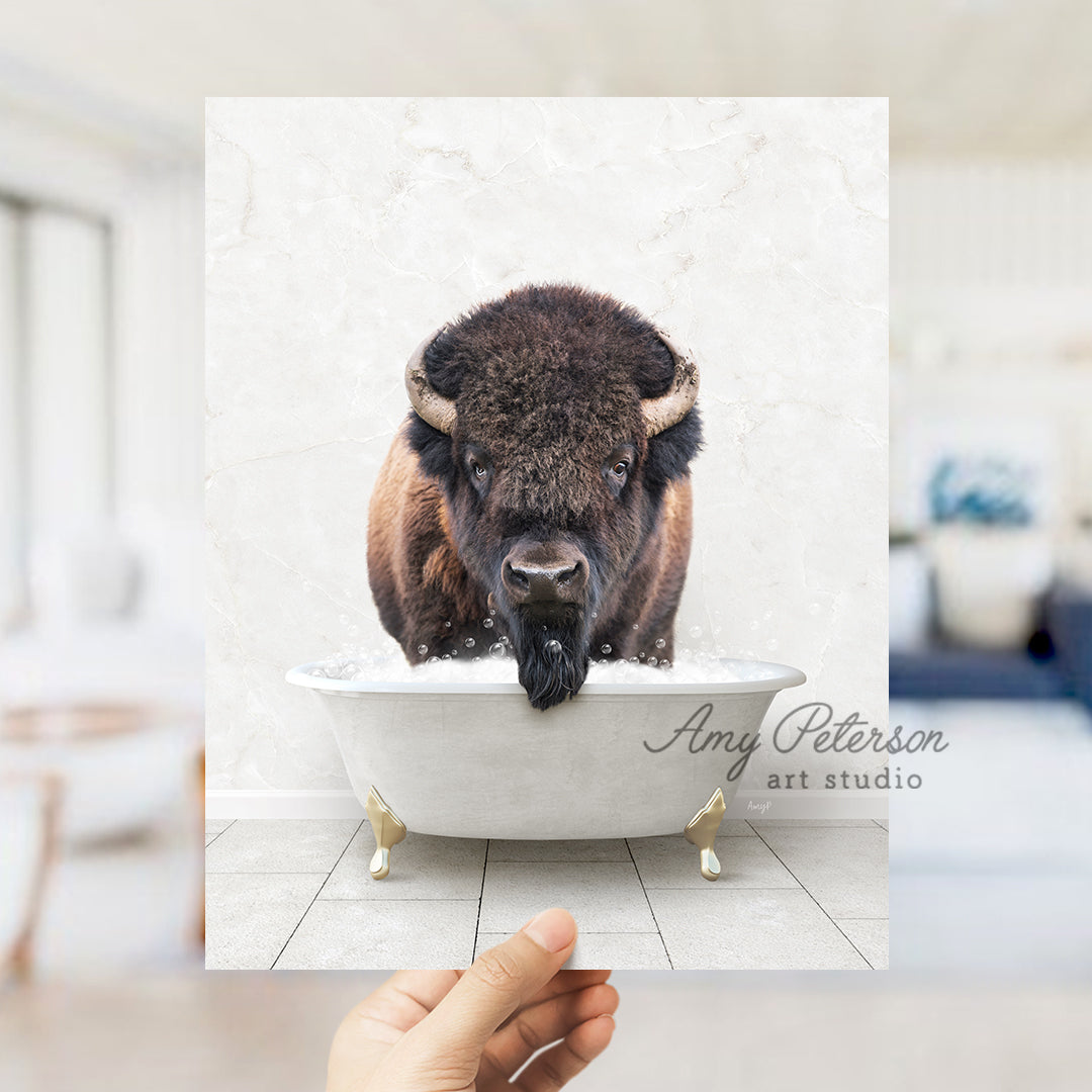 a hand holding a photo of a bison in a bathtub