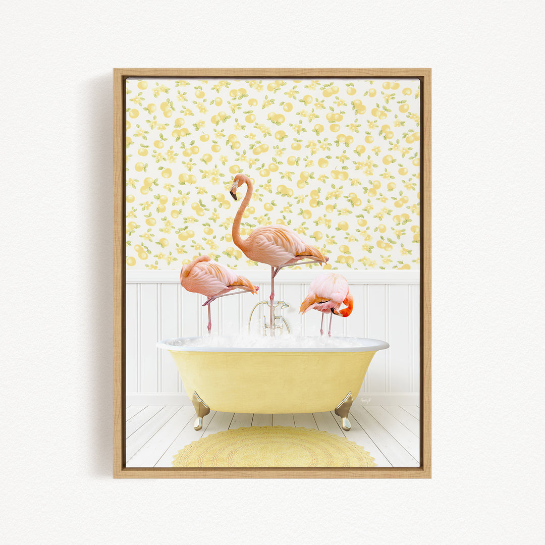 A framed image depicting three pink flamingos standing in a yellow bathtub, with a yellow floral wallpaper in the background.