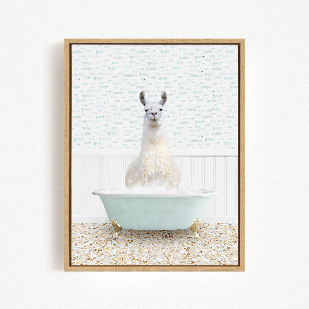 A white llama sitting in a light blue bathtub filled with bubbles, surrounded by a patterned tile floor and a white wall with a fish-themed wallpaper.