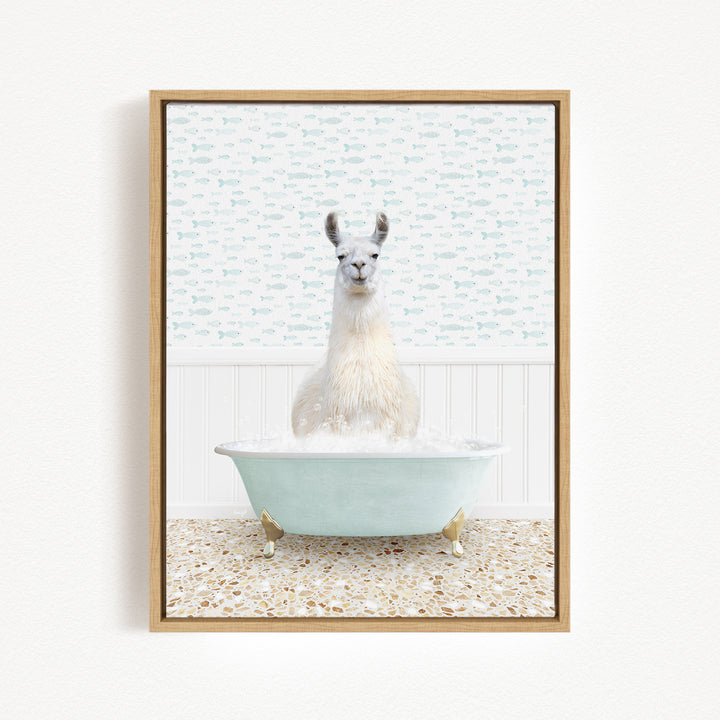 A white llama sitting in a light blue bathtub filled with bubbles, surrounded by a patterned tile floor and a white wall with a fish-themed wallpaper.