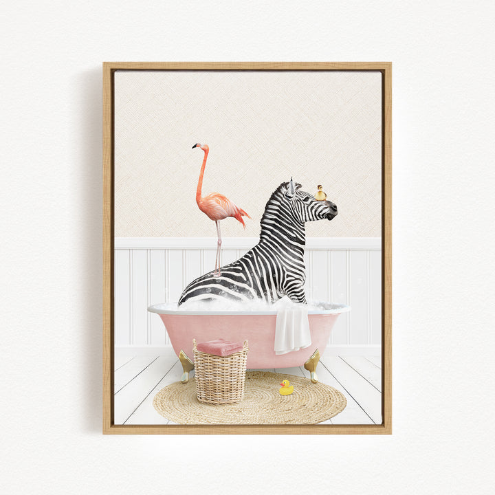 A zebra is sitting in a pink bathtub, surrounded by a pink flamingo, a yellow rubber ducky, and a basket of bath toys.