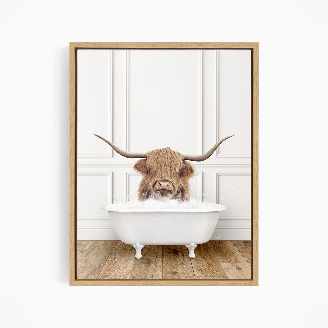 A Highland cow with long horns is sitting in a white bathtub, appearing to enjoy the bath.