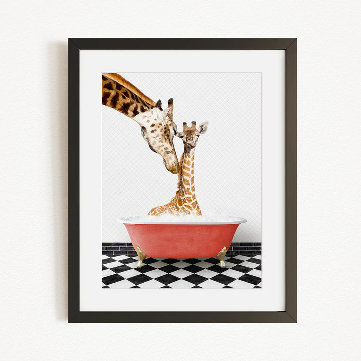 A mother giraffe and her baby giraffe are sitting together in a red bathtub, with the mother gently licking her baby.