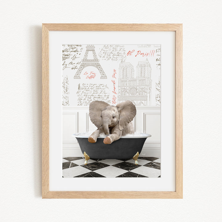 A framed image depicting a baby elephant sitting in a bathtub, with a Paris-themed background featuring the Eiffel Tower and other Parisian landmarks.