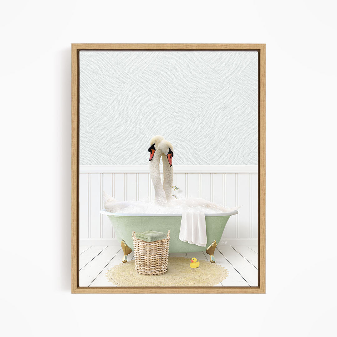 A framed image depicting a pair of swans sitting in a green bathtub filled with bubbles, surrounded by a basket of toys and a yellow rubber duck.