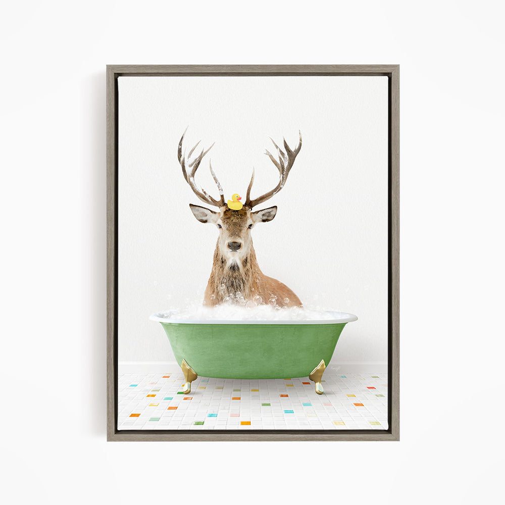 A deer with antlers is sitting in a green bathtub filled with bubbles, with a yellow rubber duck perched on its head.