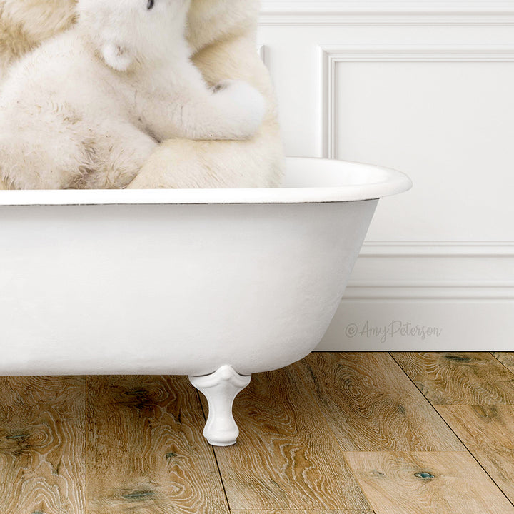 A white bathtub filled with water, with a white teddy bear sitting inside.