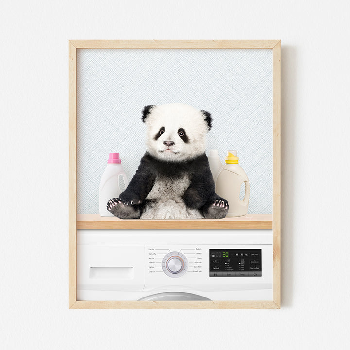 a panda bear sitting on top of a washing machine