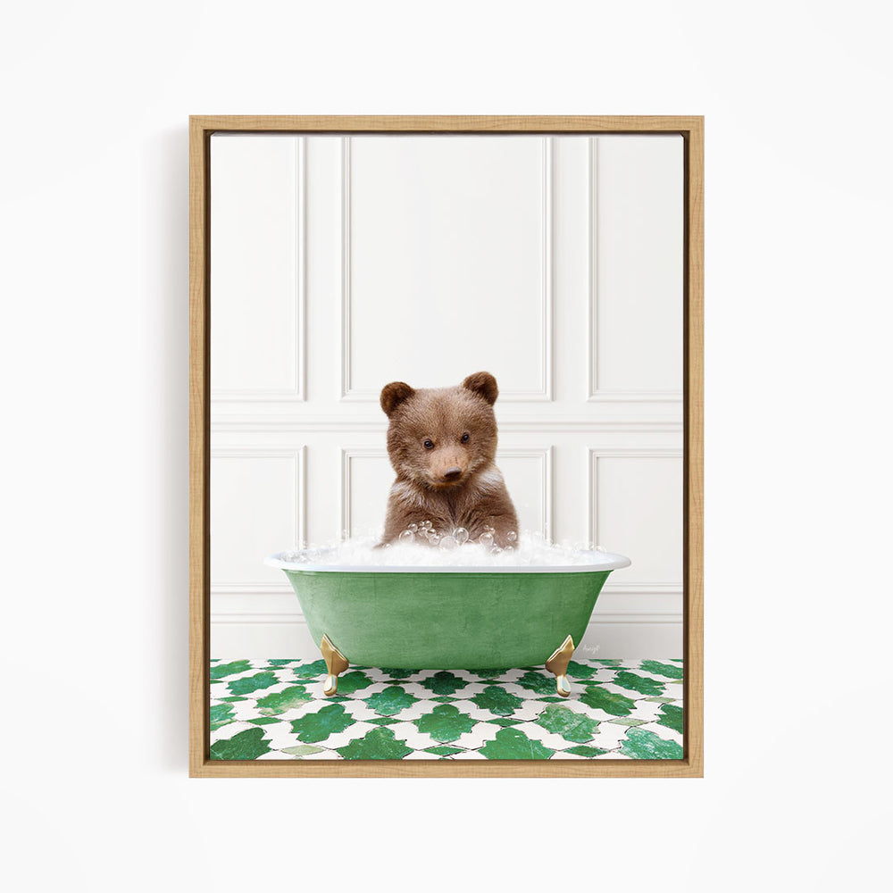 A cute brown bear sitting in a green bathtub filled with bubbles, looking directly at the camera.