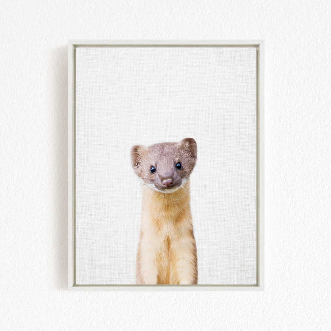 A small, furry animal with a curious expression is the focus of the image, which is a framed print displayed on a white wall.
