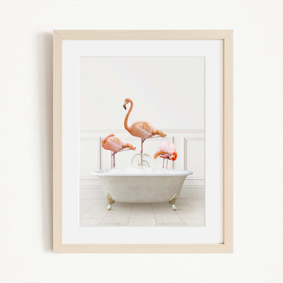 A framed image depicting three flamingos standing in a white bathtub filled with water.