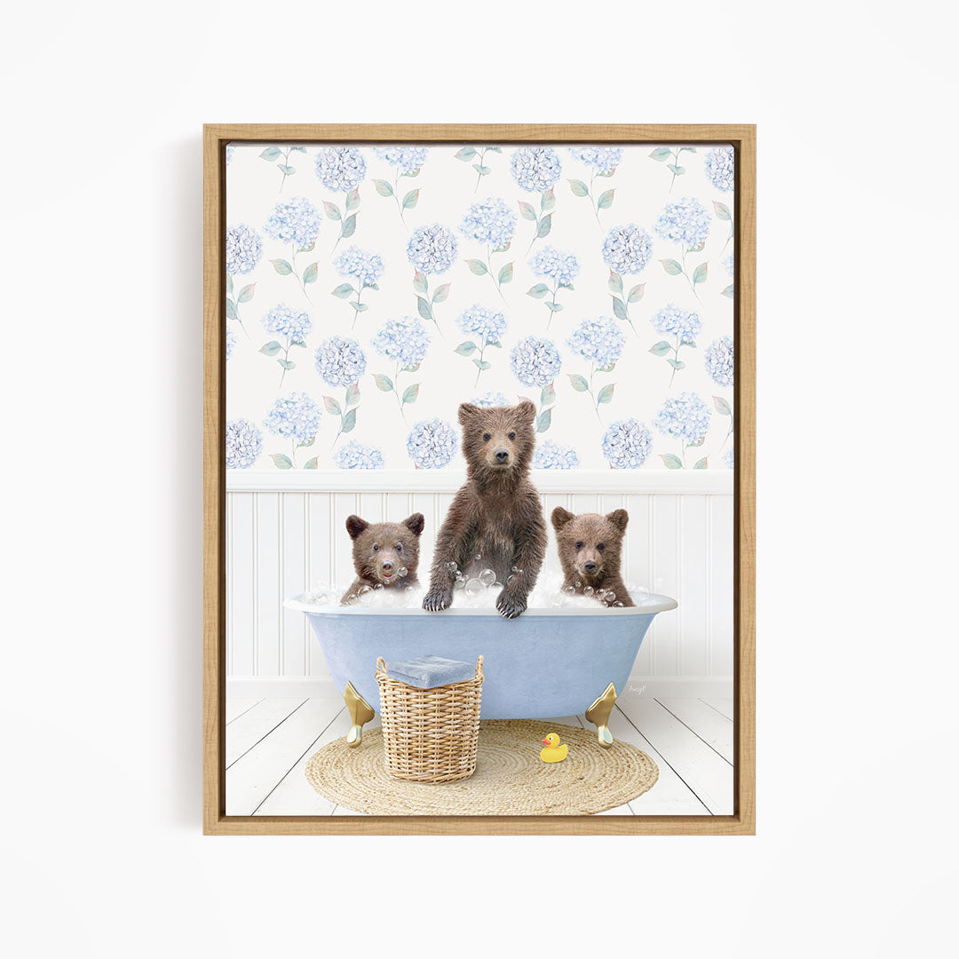 A framed image depicting three bears sitting in a bathtub filled with water, surrounded by a floral patterned wallpaper.