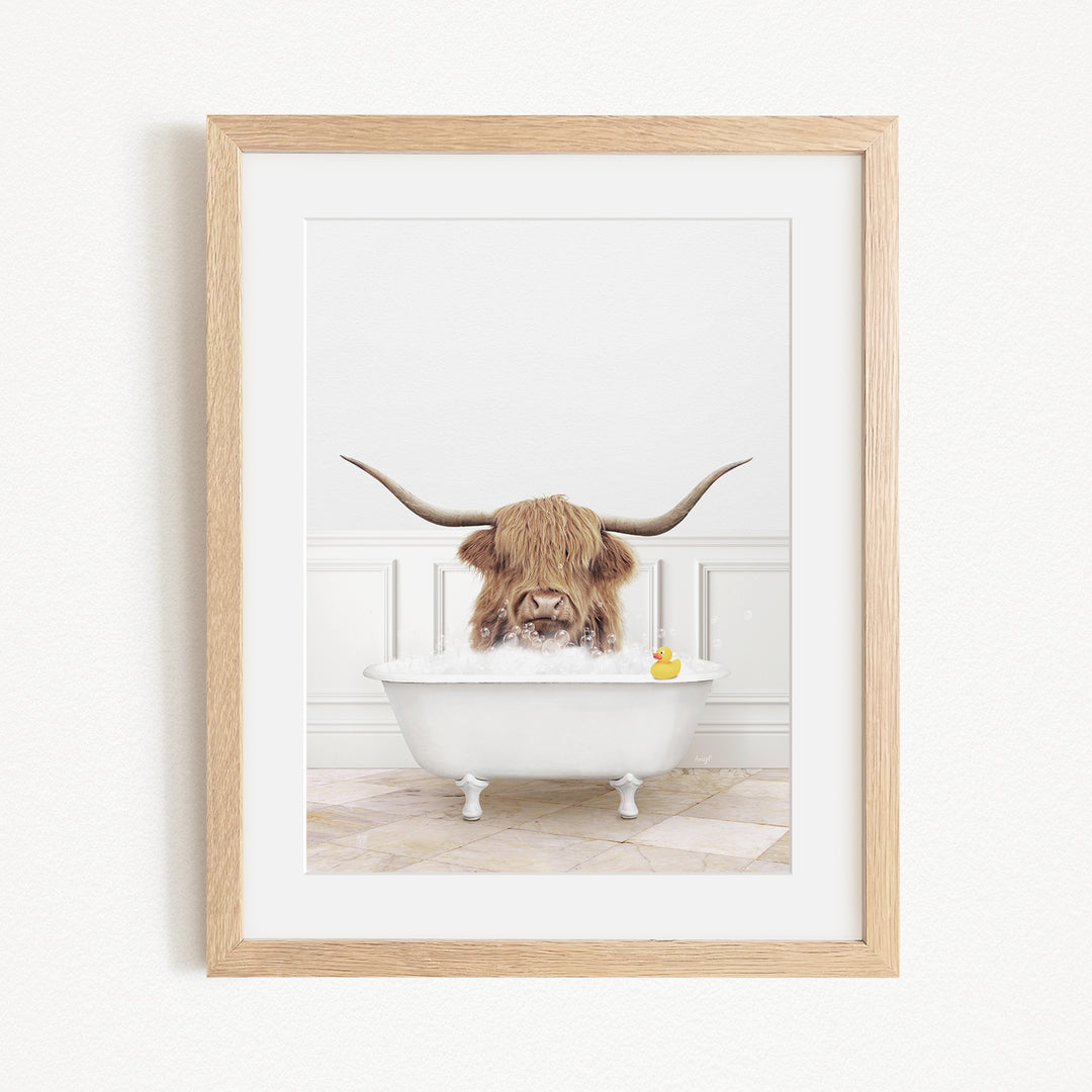 A Highland cow with large horns is sitting in a white bathtub, with a yellow rubber duck floating in the water.