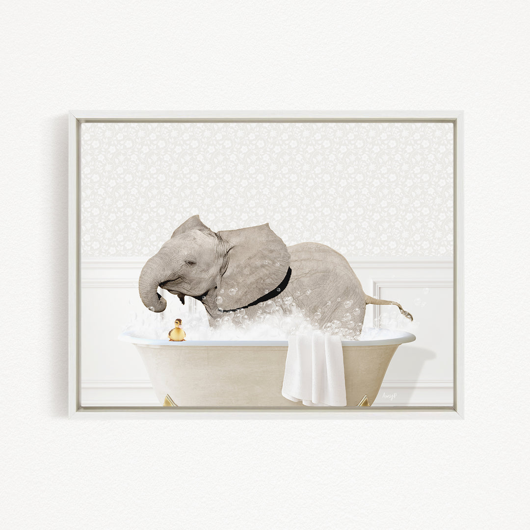 A gray elephant is sitting in a bathtub filled with water, surrounded by a white towel and a yellow rubber duck.