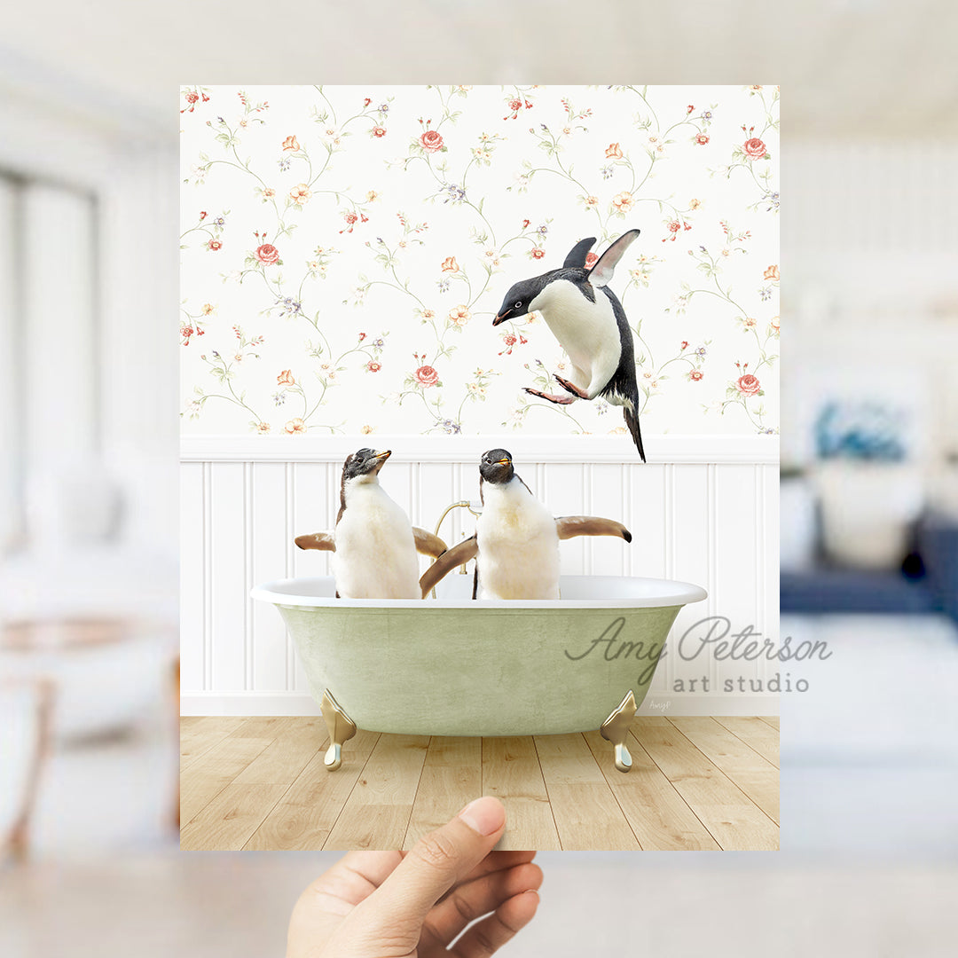 a hand holding up a card with two penguins in a bathtub