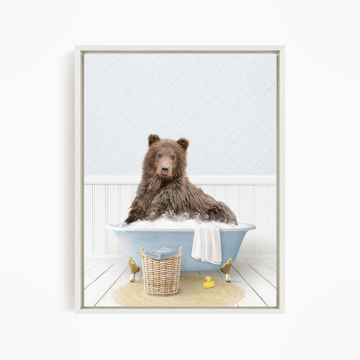 A brown bear sitting in a blue bathtub filled with water, surrounded by a yellow rubber duck and a wicker basket.