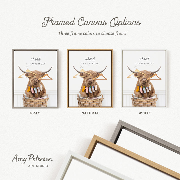 The image is a framed canvas option featuring a framed image of a Highland cow sitting in a basket with clothes. The canvas options include three different frame colors: gray, natural, and white.