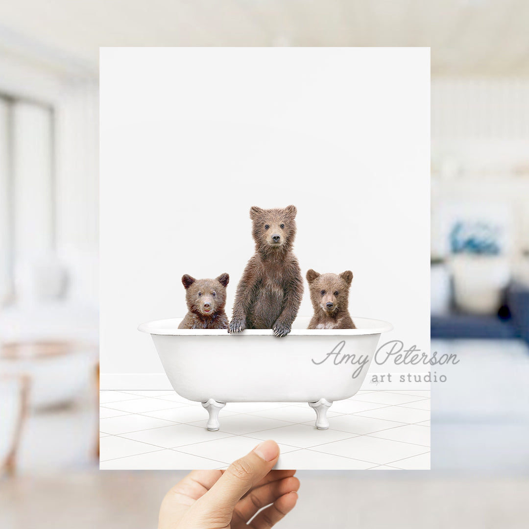 a person holding up a card with three bears in a bathtub