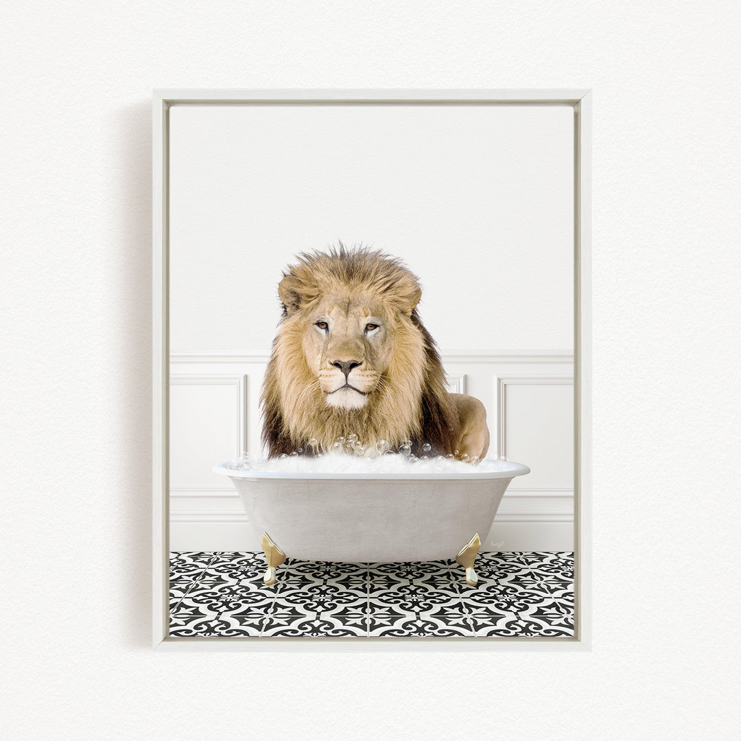 A lion sitting in a white bathtub filled with bubbles, looking directly at the camera.