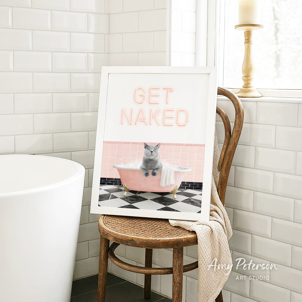 A framed image of a cat sitting in a pink bathtub, with the text "GET NAKED" displayed on the frame.