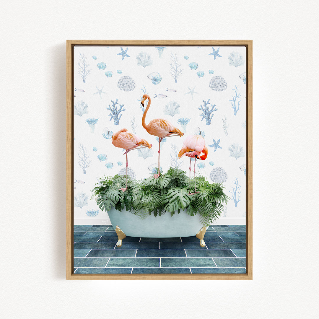 A framed image depicting three pink flamingos standing in a bathtub filled with green plants, set against a background of blue and white floral patterns.