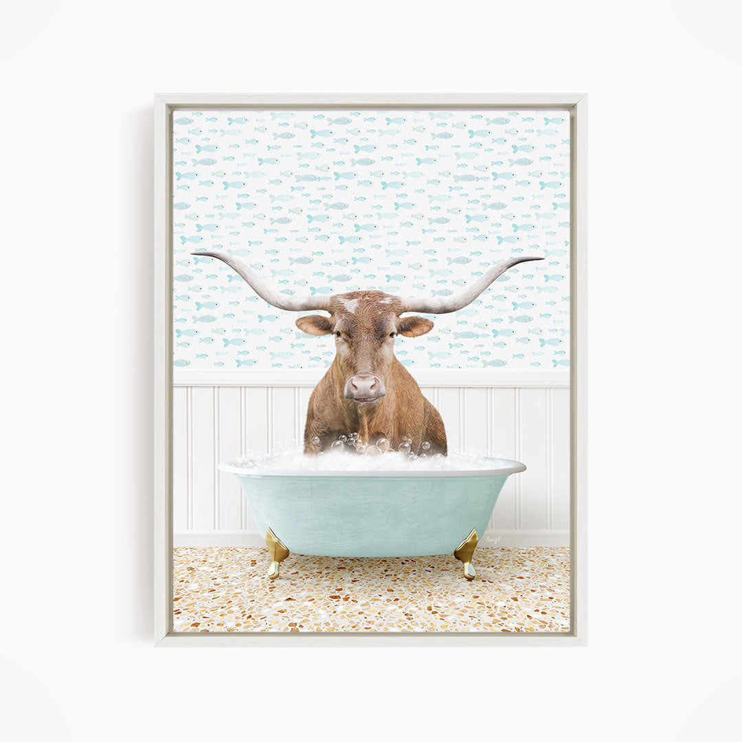 A brown cow with large horns is sitting in a light blue bathtub filled with bubbles, surrounded by a patterned wall.
