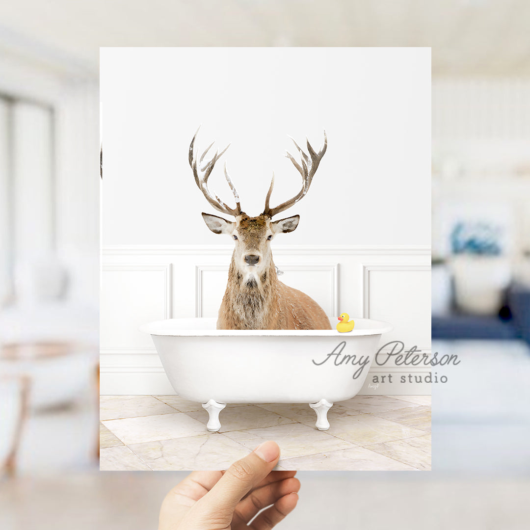 a hand holding up a photo of a deer in a bathtub