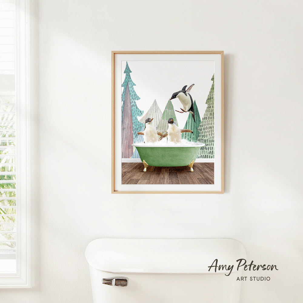 A framed print of two penguins sitting in a green bathtub, surrounded by a snowy landscape with trees and a bird in flight.