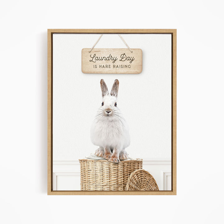 A white rabbit sitting in a wicker basket, with a wooden sign above that says "Laundry Day is Rare Raising".