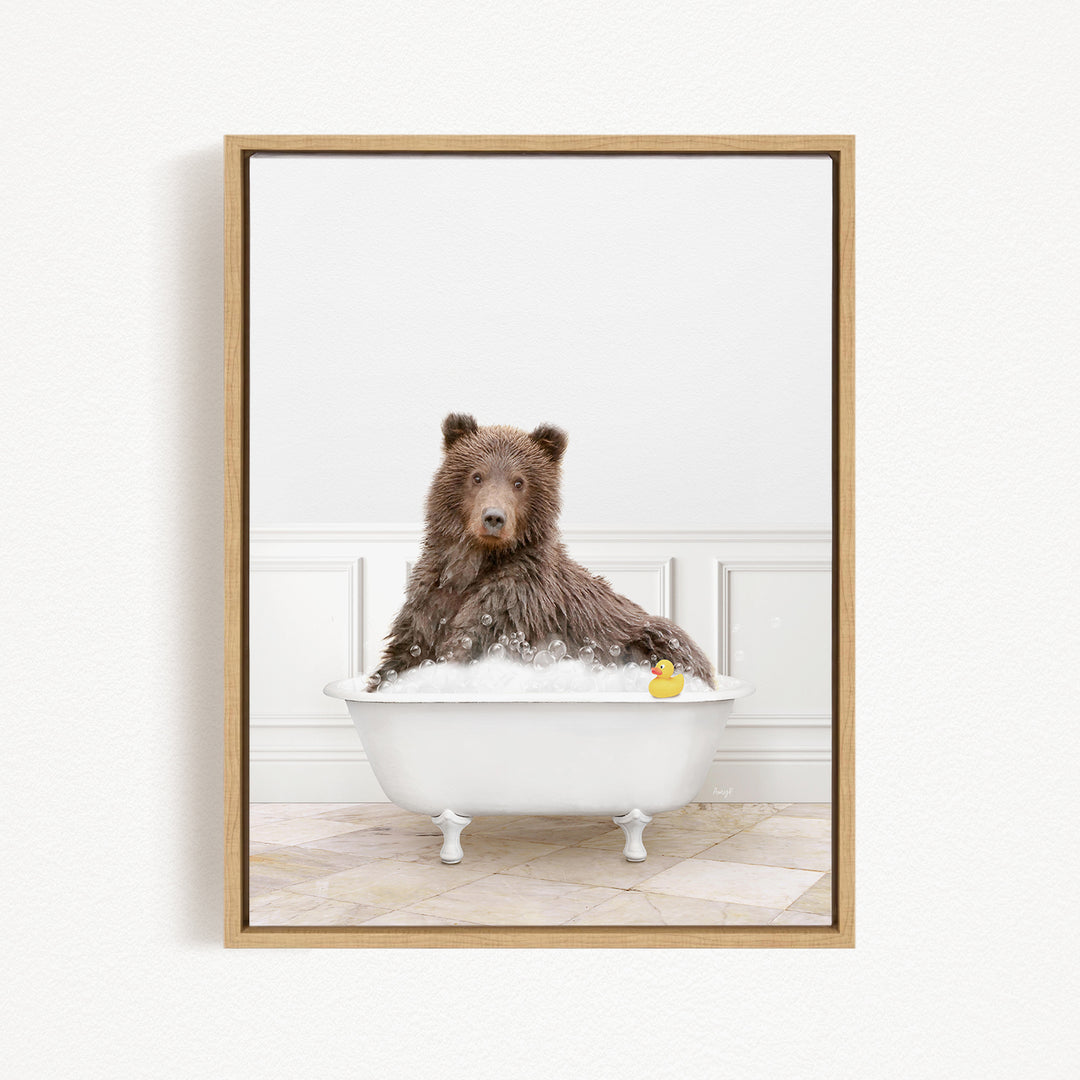 A brown bear sitting in a white bathtub, with a rubber duck floating in the water.