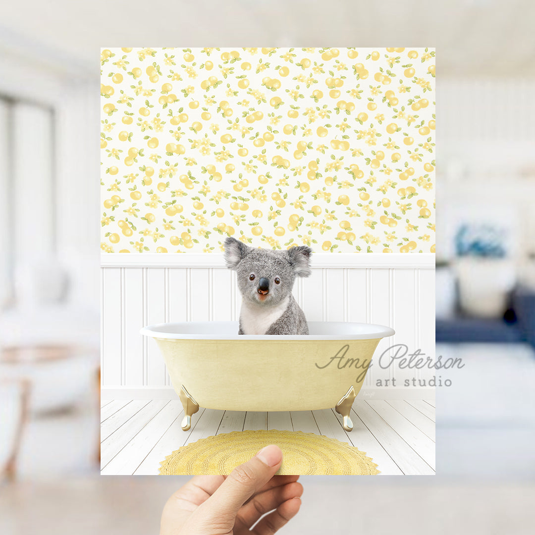 a hand holding up a picture of a koala in a bathtub