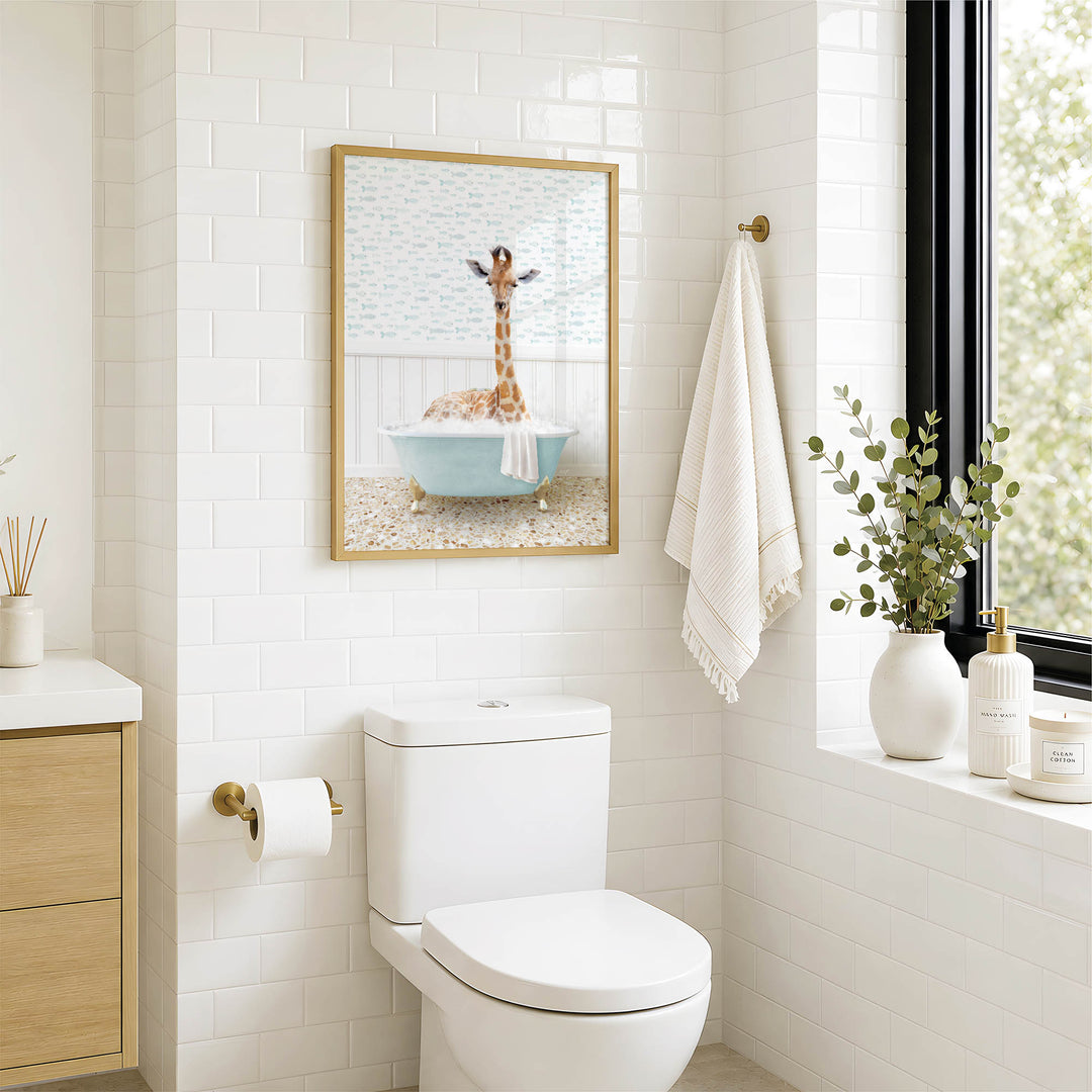 a bathroom with a white toilet, a framed picture of a giraffe in a bathtub, and a towel hanging on the wall.