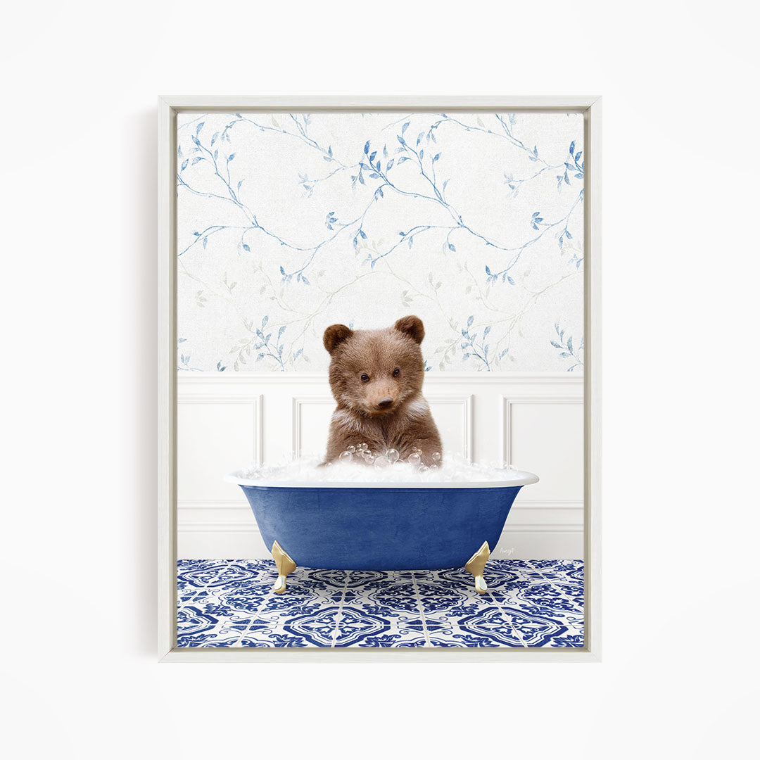A brown bear sitting in a blue bathtub filled with bubbles, surrounded by a blue and white patterned floor.
