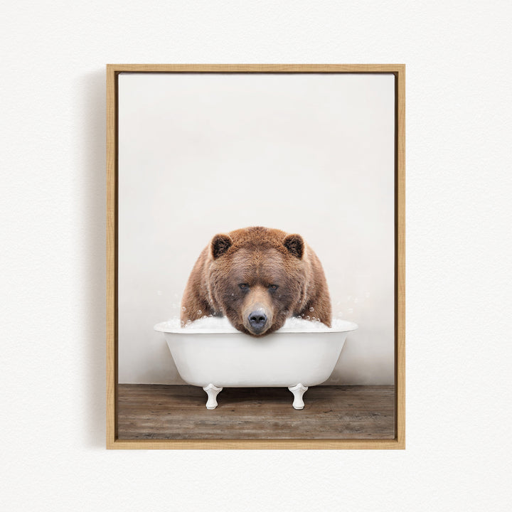 A brown bear sitting in a white bathtub, appearing to be enjoying a relaxing bath.