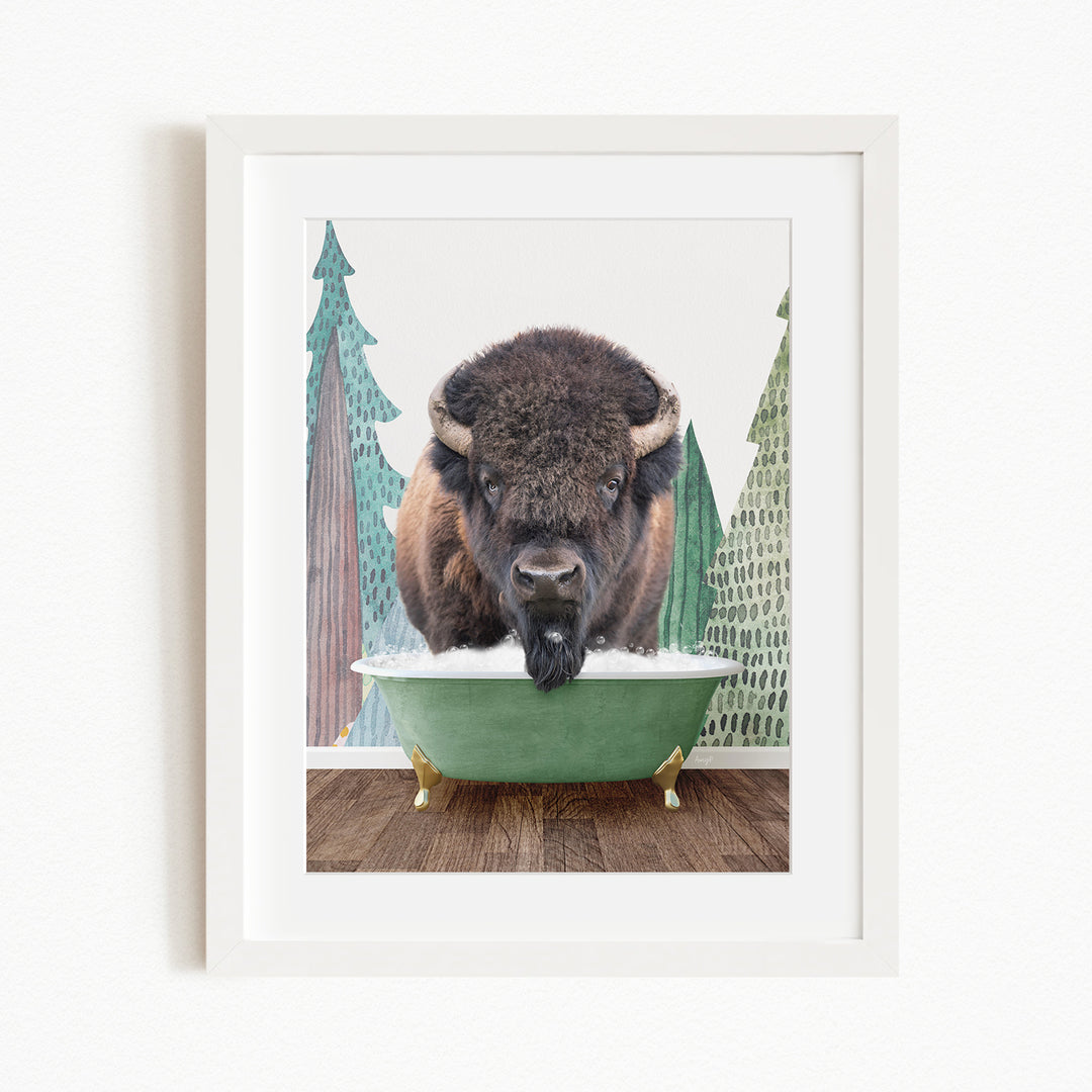 A bison with large horns is standing in a green bathtub, surrounded by pine trees and a snowy landscape.