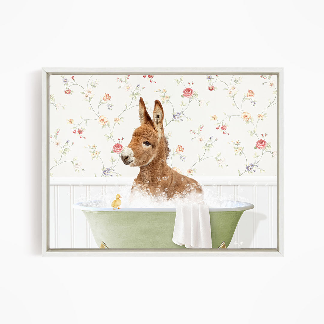 A brown donkey is sitting in a green bathtub filled with water, surrounded by a floral wallpaper.