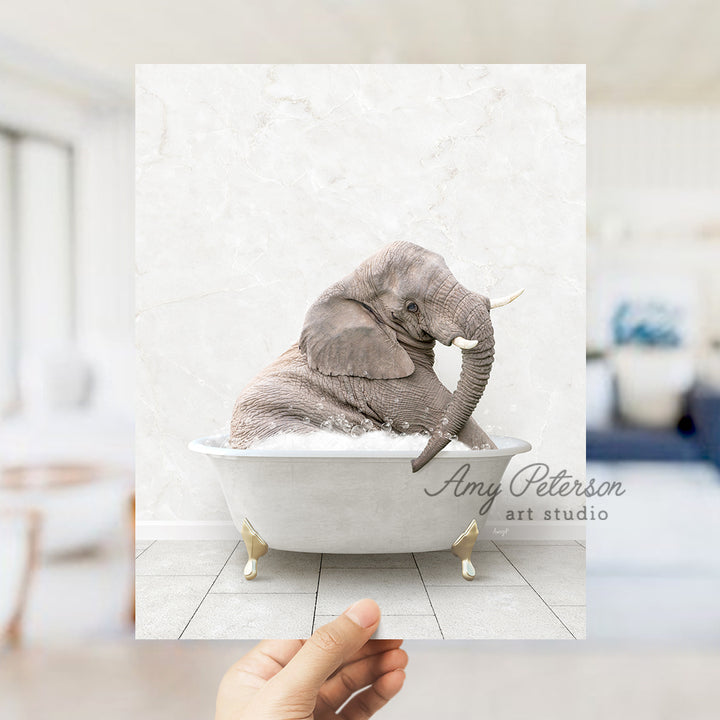 a hand holding up a picture of an elephant in a bathtub