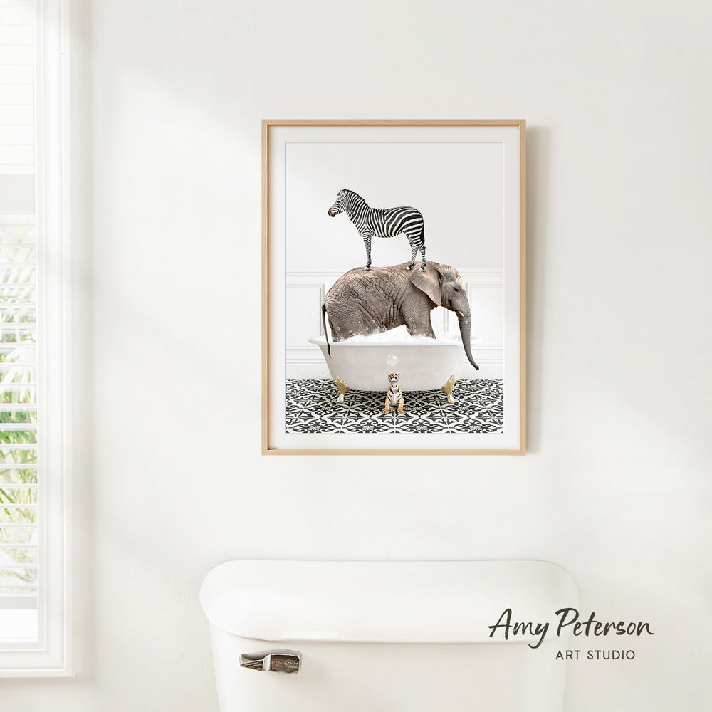 A framed image of a zebra standing on an elephant's back, both in a bathtub, is hanging on a white wall.